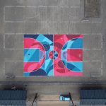 Aerial view of a vibrant, geometric temporary basketball court painted in bright pinks and blues using eco-friendly temporary paint in a public square in Belgium.